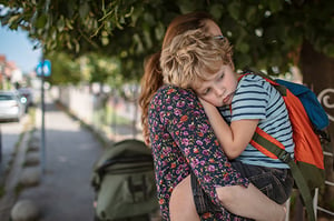 Mother-holding-unhappy-preschooler