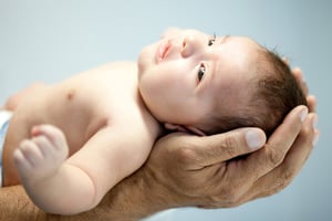 Portrait of a man holding a baby in his hands