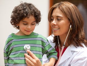 female pediatrician and a little boy where both are smiling