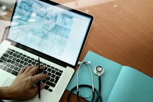 top view of Medicine doctor hand working with modern computer and smart phone on wooden desk as medical concept-1